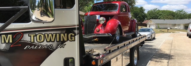M2 Towing on a flatbed or rollback transporting a vintage car