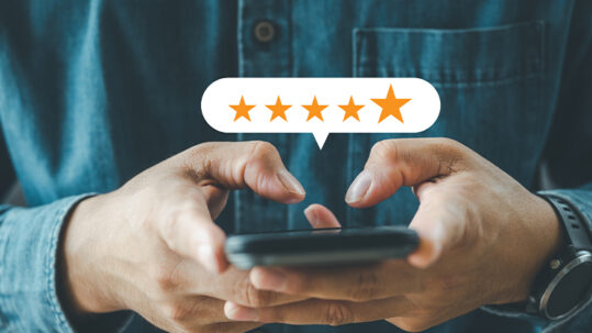 A person using their mobile phone to leave a customer review