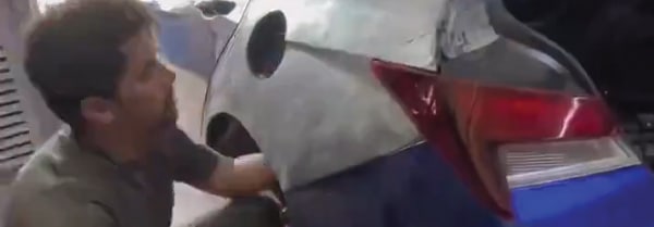 A man refurbishing a salvaged vehicle